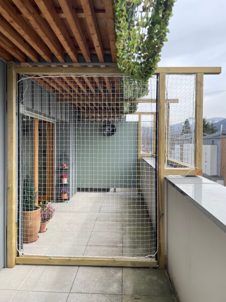 Catio avec porte coulissante en filet sur balcon d'appartement