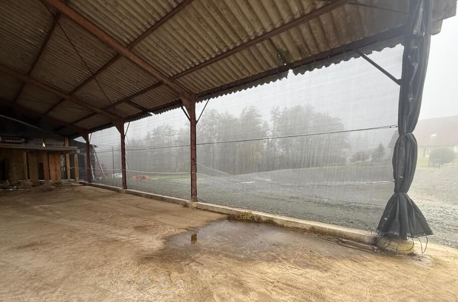 Filet brise-vent noir sur hangar pour chevaux