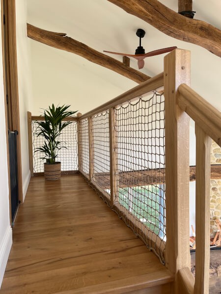 Filet de protection sur garde-corps en bois d'un palier