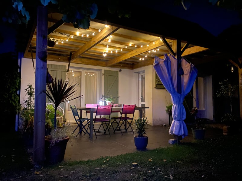 Filet d'ombrage ivoire sur pergola en bois pour lasser passer l'eau