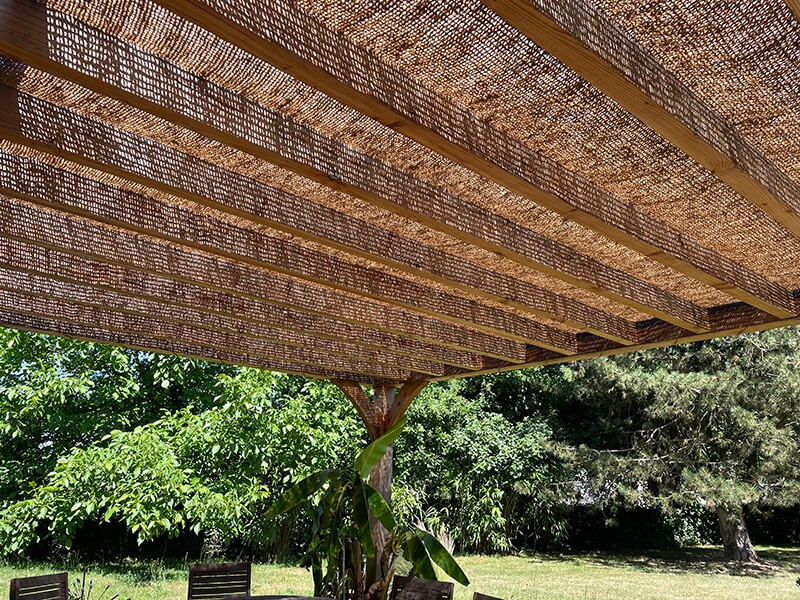 Toile d'ombrage coco sur pergola bois
