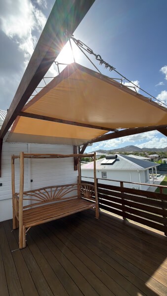 Bâche d'ombrage ivoire tendue sur pergola de terrasse de piscine