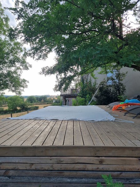 Filet anti-feuilles pour une piscine avec terrasse en bois en hauteur