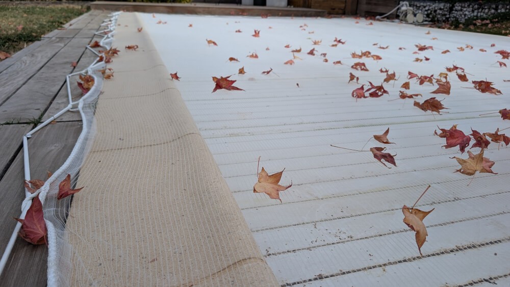 Filet protection de piscine au sol contre les feuilles d'Automne