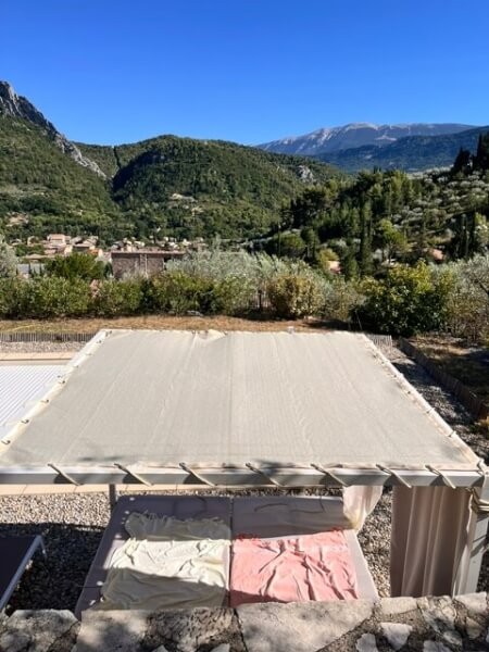 Toile d'ombrage tendue sur une structure de pergola