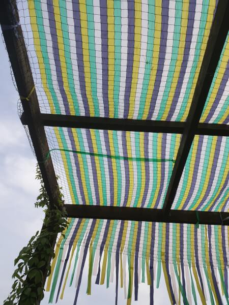 Usage original d'un filet pour recouvrir une terrasse avec bandes colorées