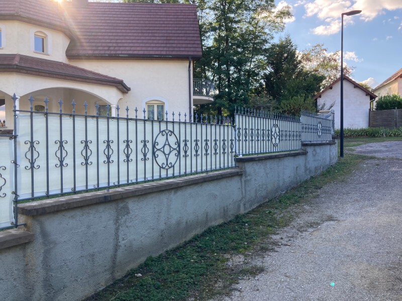 Filet brise-vue couleur sur clôture en fer forgé
