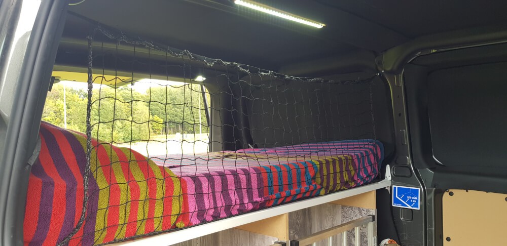 Filet séparateur installé dans lit camping aménagé